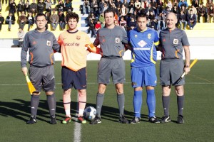 El trio arbitral con los capitanes del partido