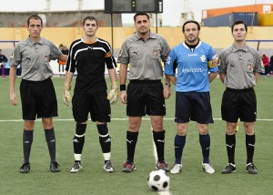 El trio arbitral con los capitanes del partido