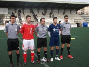 El trio arbitral con los capitanes del partido