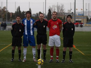 El trío arbitral con los capitanes del partido