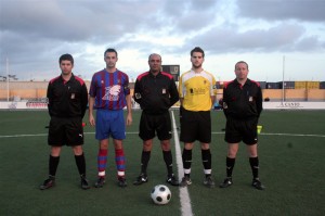 El trio arbitral con los capitanes del partido