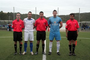 El trío arbitral con los capitanes del partido