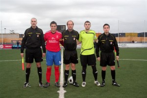 El trío arbitral con los capitanes del partido