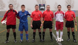 El trio arbitral con los capitanes del partido