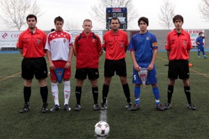 El trio arbitral con los capitanes del partido