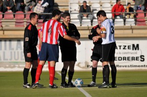 El trío arbitral con los capitanes del partido