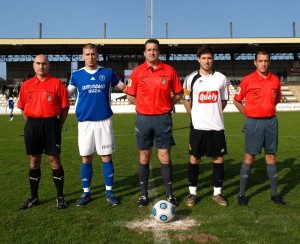 El trío arbitral con los capitanes del partido