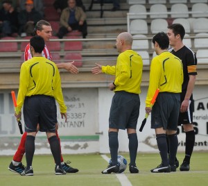 El trio arbitral con los capitanes del partido