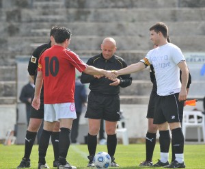 El trio arbitral con los capitanes del partido