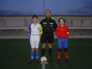 El arbitro con los dos capitanes del partido