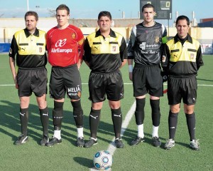 El trío arbitral con los capitanes del partido