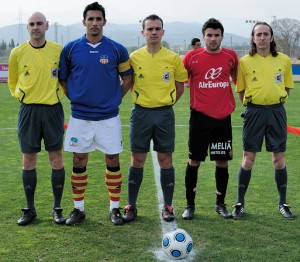 El trio arbitral con los capitanes del partido