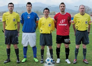 El colegiado con los capitanes del partido