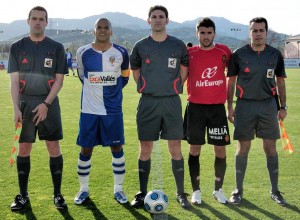 El trio arbitral con los capitanes del partido