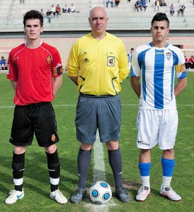 El colegiado del partido con los dos capitanes del partido