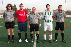 El trio arbitral con los capitanes del partido