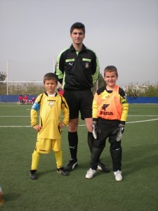 Los dos capitanes con el arbitro del partido