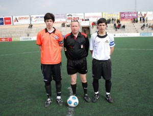 El colegiado con los capitanes del partido