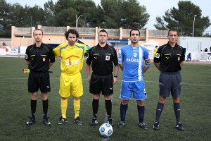 El trio arbitral con los capitanes del partido