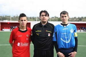 El colegiado con los dos capitanes del partido