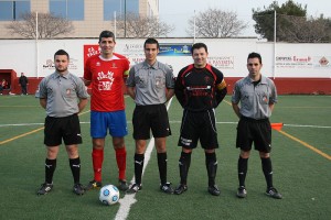 El trio arbitral con los capitanes del partido