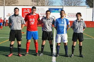 El trio arbitral con los capitanes del partido