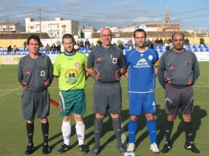 El trio arbitral con los capitanes del partido