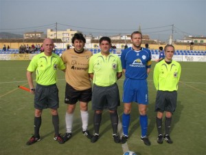 El trio arbitral con los capitanes del partido