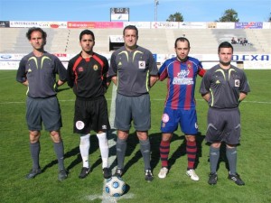 El trio arbitral con los capitanes del partido