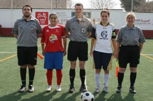 El trio arbitral con las capitanas del partido