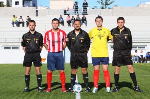 El trío arbitral con los capitanes del partido