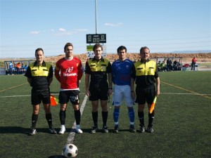 El trío arbitral con los capitanes del partido