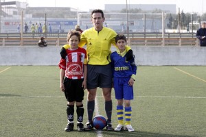 El colegiado con los dos capitanes del partido