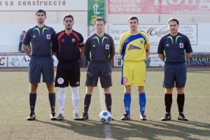 El trio arbitral con los capitanes del partido