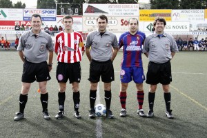 El trío arbitral con los capitanes del partido