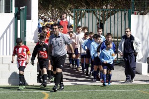 El colegiado saliendo al campo con los dos equipos