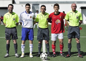 El trio arbitral con los capitanes del partido