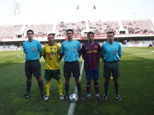 El colegiado con los capitanes del partido