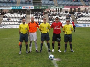 El trio arbitral con los capitanes del partido