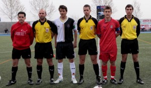 El trio arbitral con los capitanes del partido