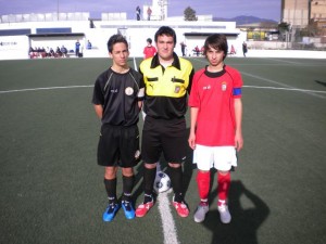 Ambos capitanes con el colegiado del encuentro