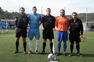 El trío arbitral con los capitanes del partido