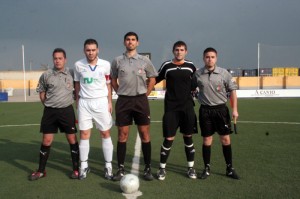 El trio arbitral con los capitanes del partido