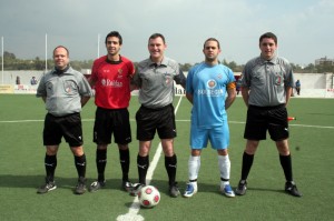 El trío arbitral con los capitanes del partido