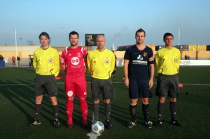 El trío arbitral con los capitanes del partido