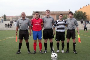 El trío arbitral con los capitanes del partido