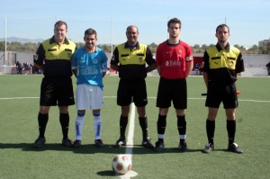 El trio arbitral con los capitanes del partido