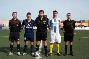 El trio arbitral con los capitanes del partido