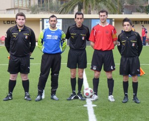 El trio arbitral con los capitanes del partido