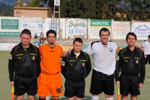 El trío arbitral con los capitanes del partido